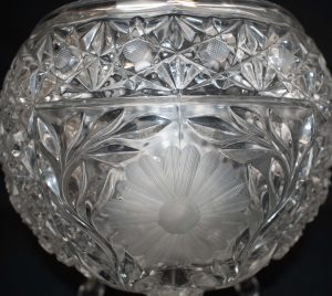 Close up image of cut glass punch bowl with etch daisy in the middle